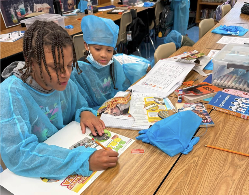 two students working together on a poster board