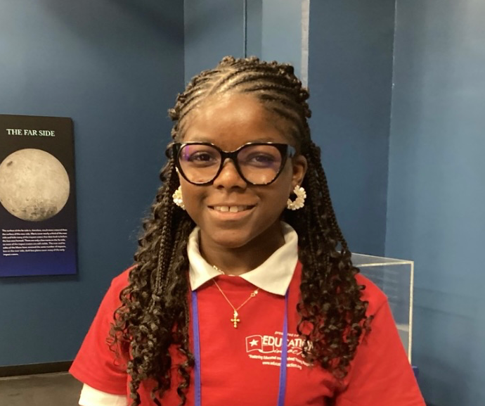 girl smiling at the camera with glasses wearing a red shirt