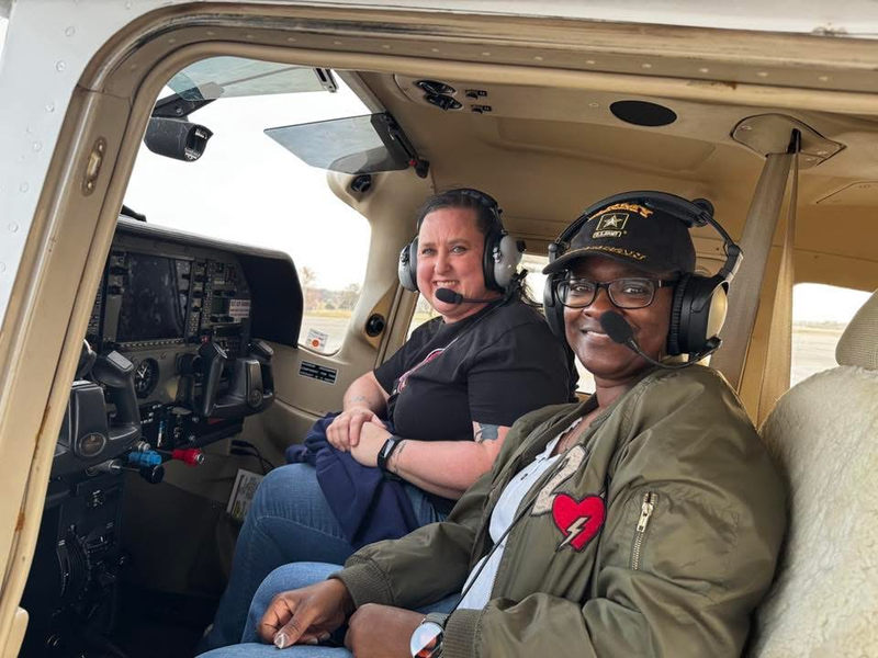 two women smiling at the camera with their headgear on ready for take off