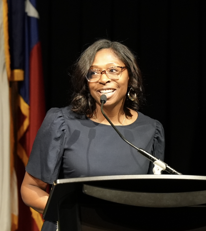 patrice robinson at a podium speaking and smiling