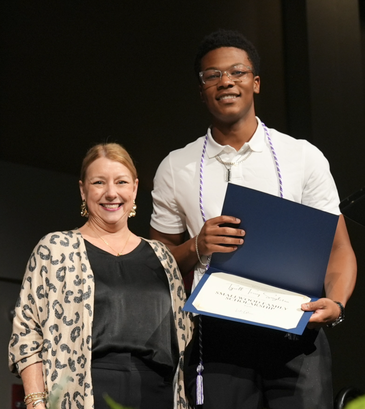 a smiling woman with a smiling student holding a certificate