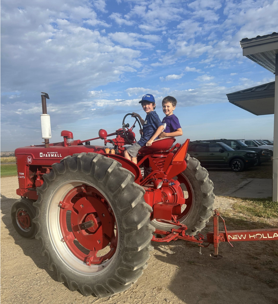 two boys on a red tractor