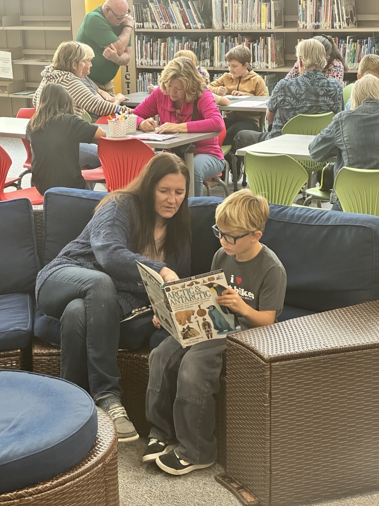 student reading with grandmother in library