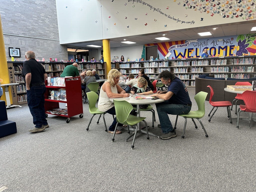 students doing activities with grandparents in library