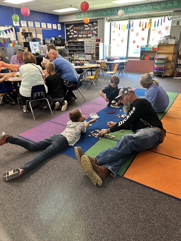 students and grandparents doing game on floor