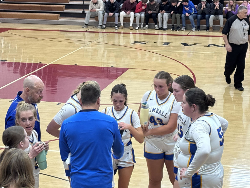 Girls basketball huddle with their coaches