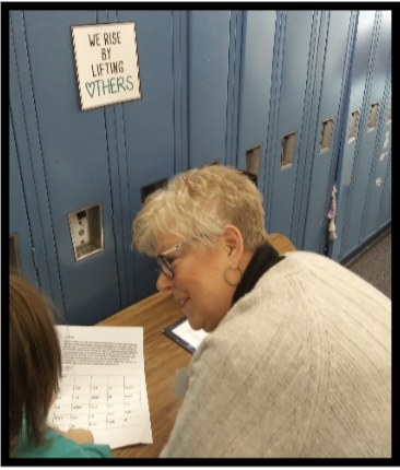 grandma judy reading with student by lockers