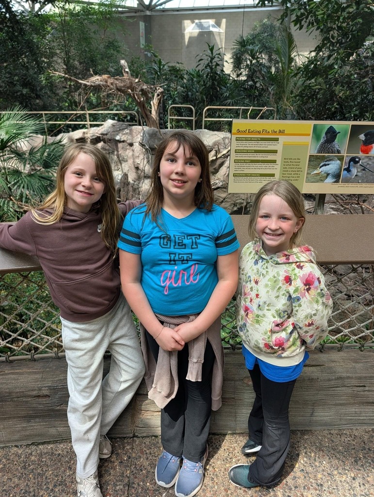 3 girls in front of bird exhibit