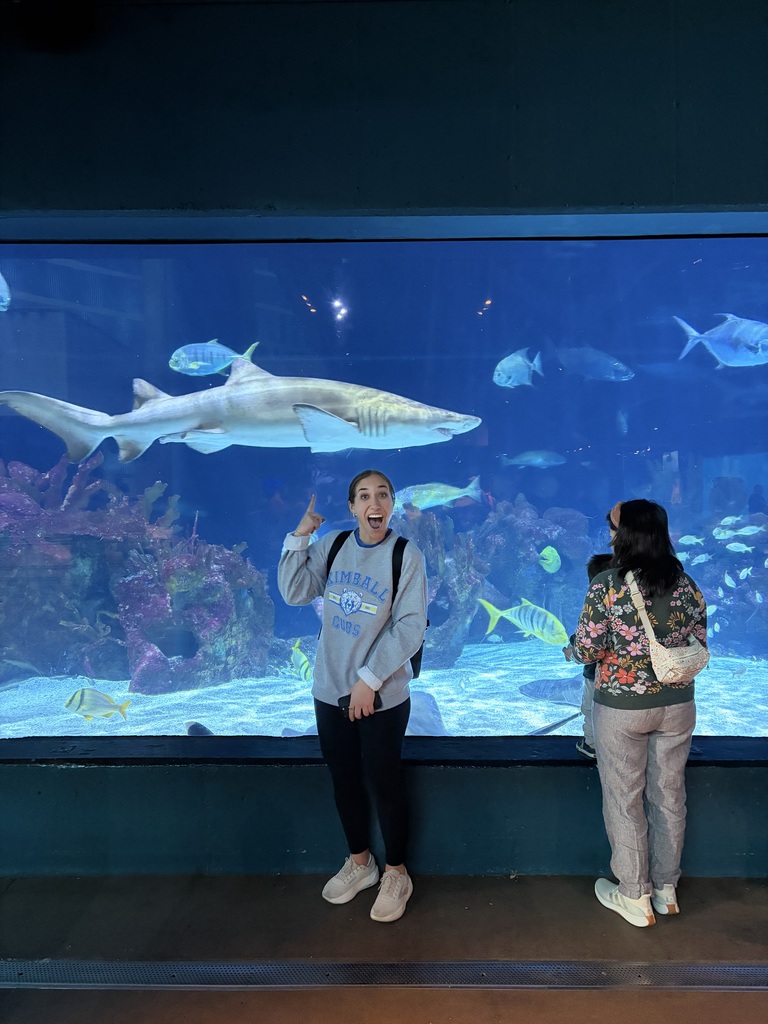teacher in ftont of shark tank exhibit