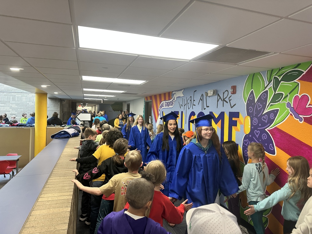 senior walking halls with elementary studends cheering them on