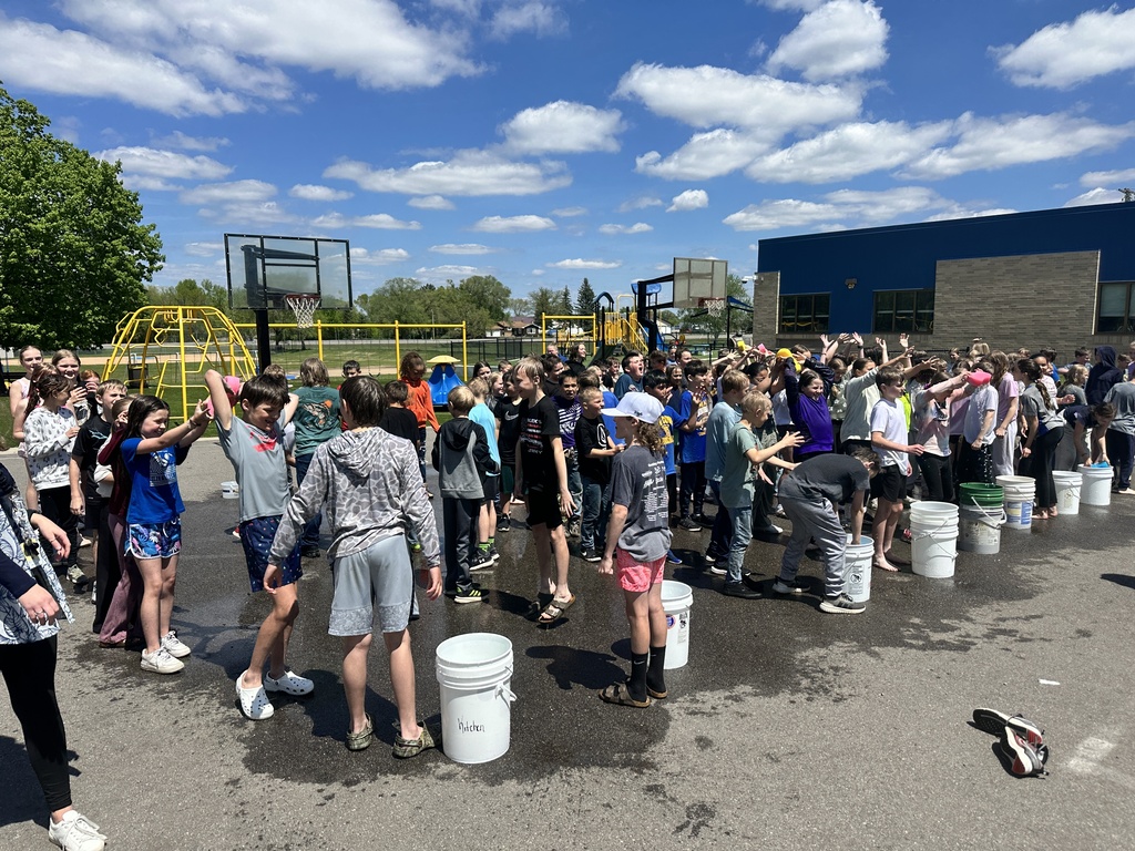 students doing water relays on the playground
