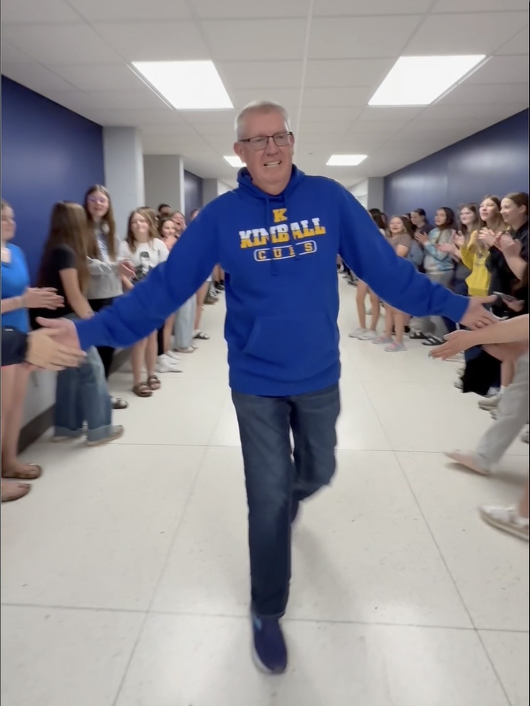 Mr. Strand walking student lined hallway