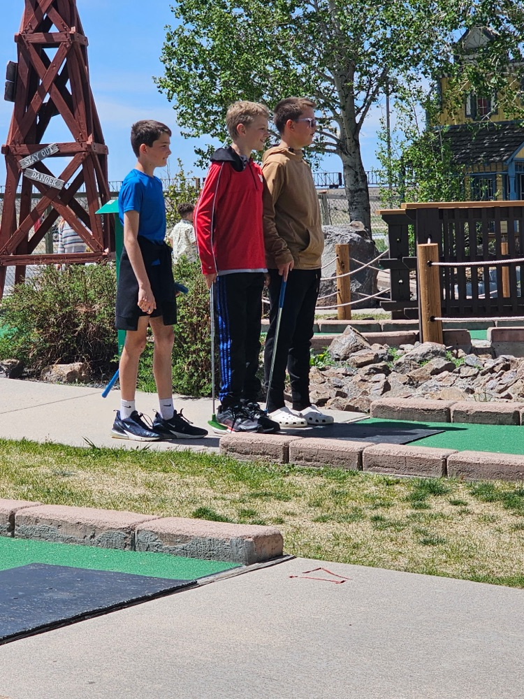 three boys golfing
