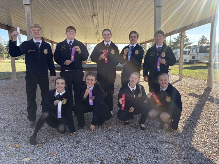 Students wearing black uniforms and ties pose for a photo with medals around their necks.