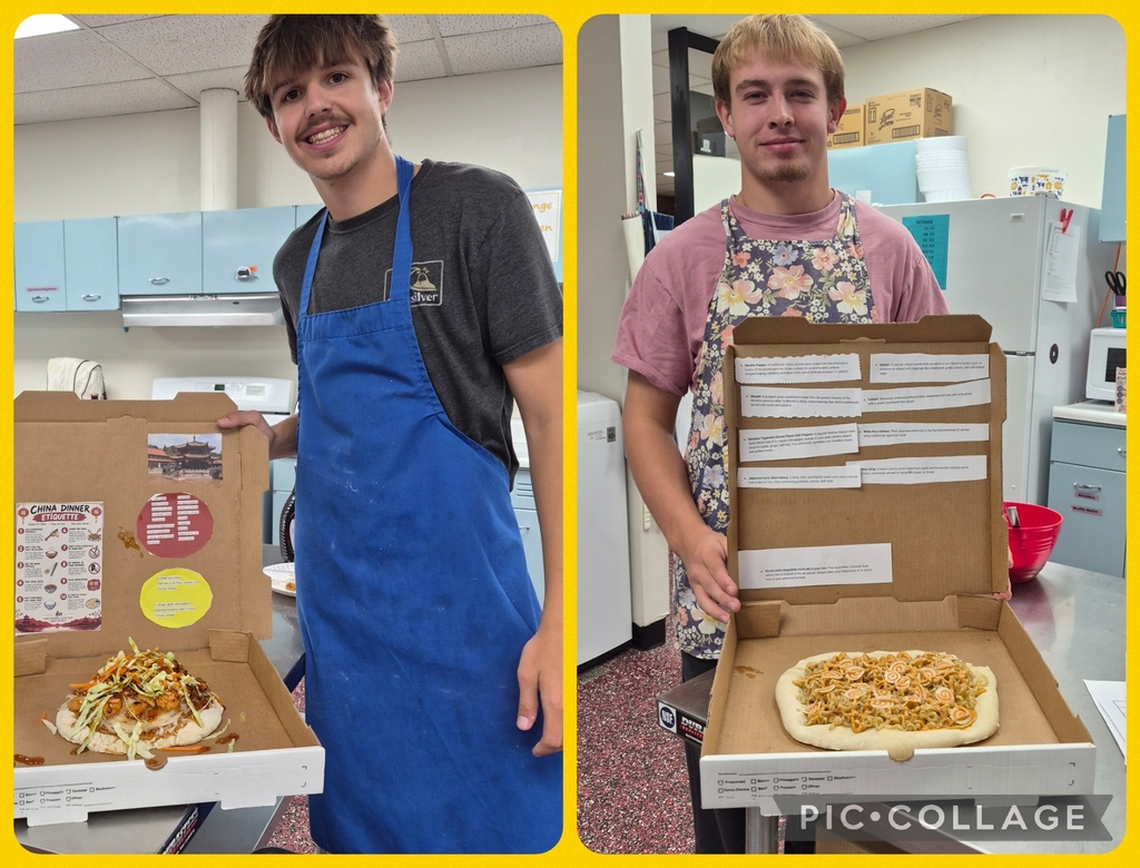 Two boys in aprons hold pizza boxes, one showing a pizza and the other showing a pizza box.