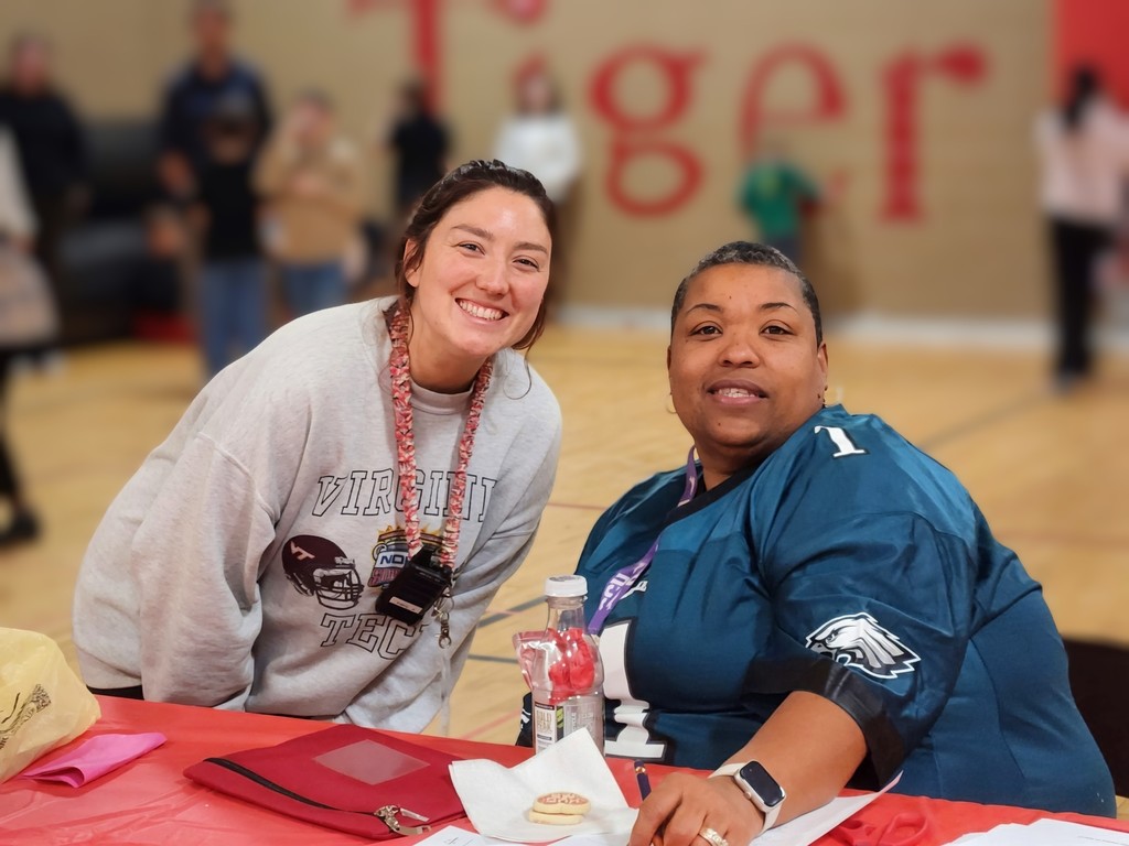 Two staff smiling at a table.