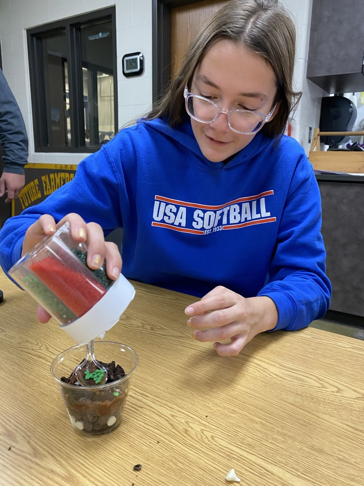 Cayla applying plant litter to her dirt cup.