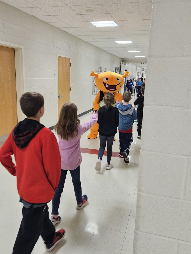 Plory poses for pictures with students.