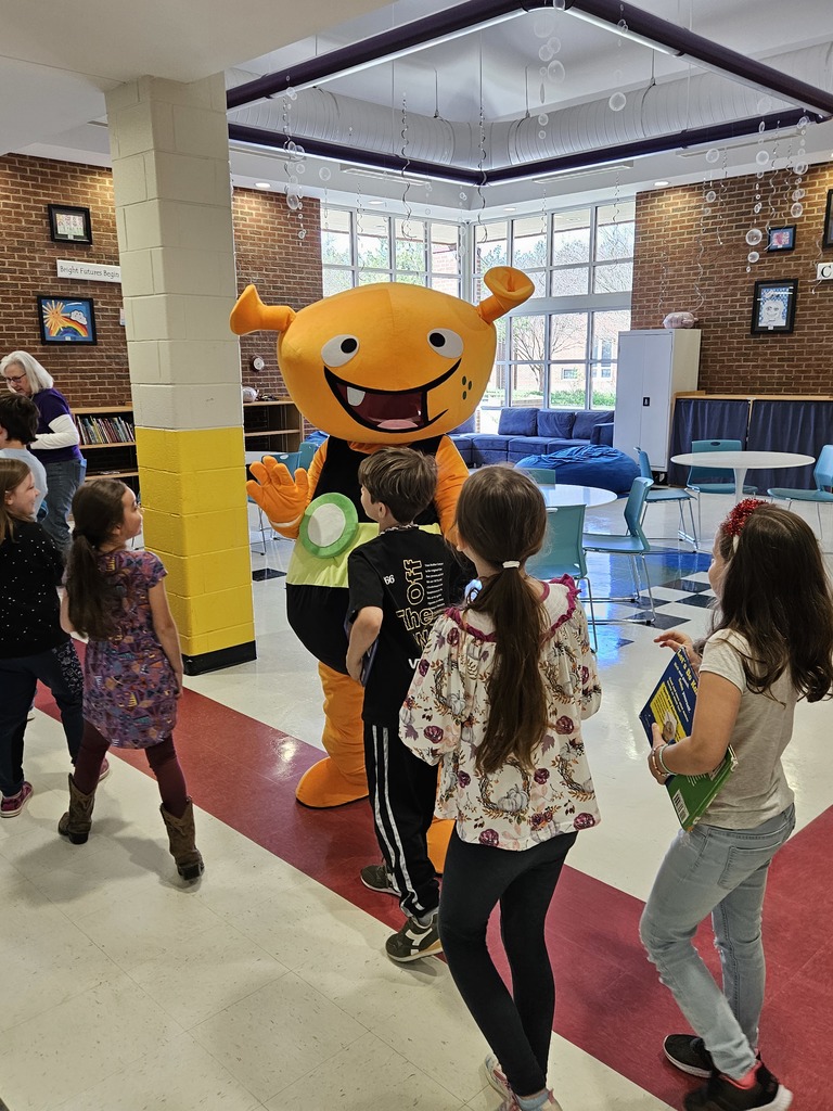 Plory poses for pictures with students.