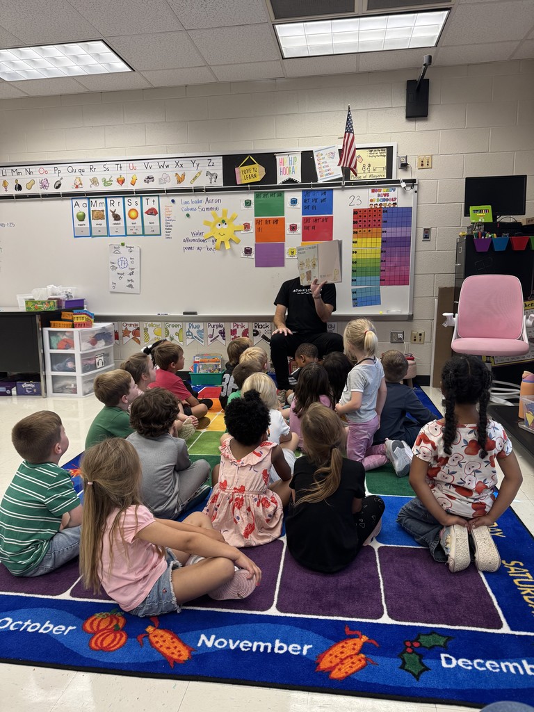 Mr. Horne reading a book to a class.
