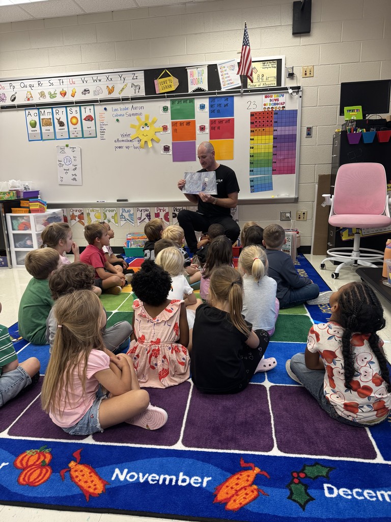 Mr. Horne reading a book to a class.