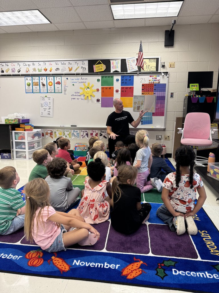 Mr. Horne reading a book to a class.