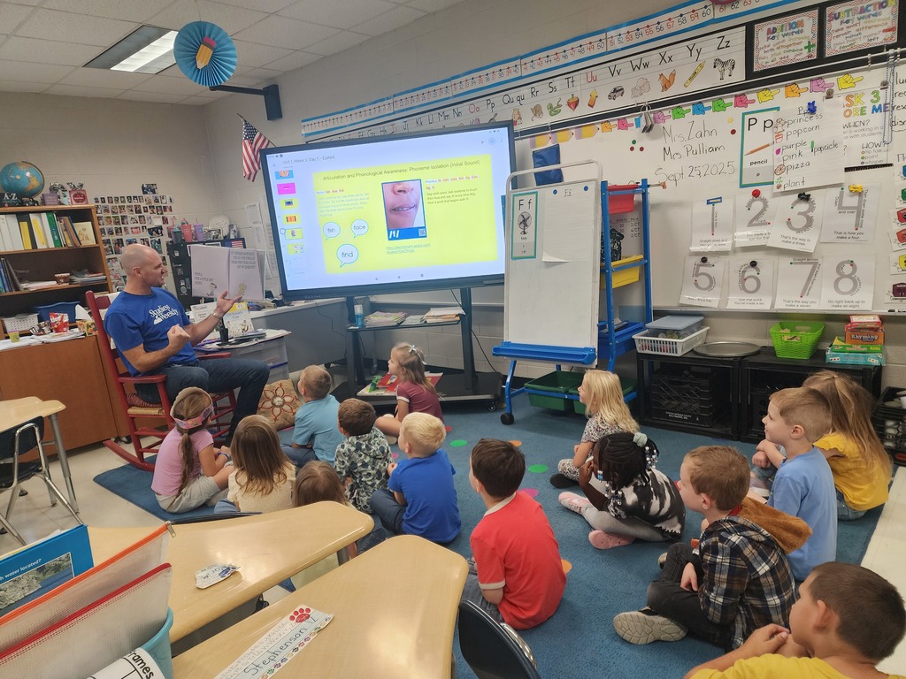 Mr. Horne reading a book to a class.