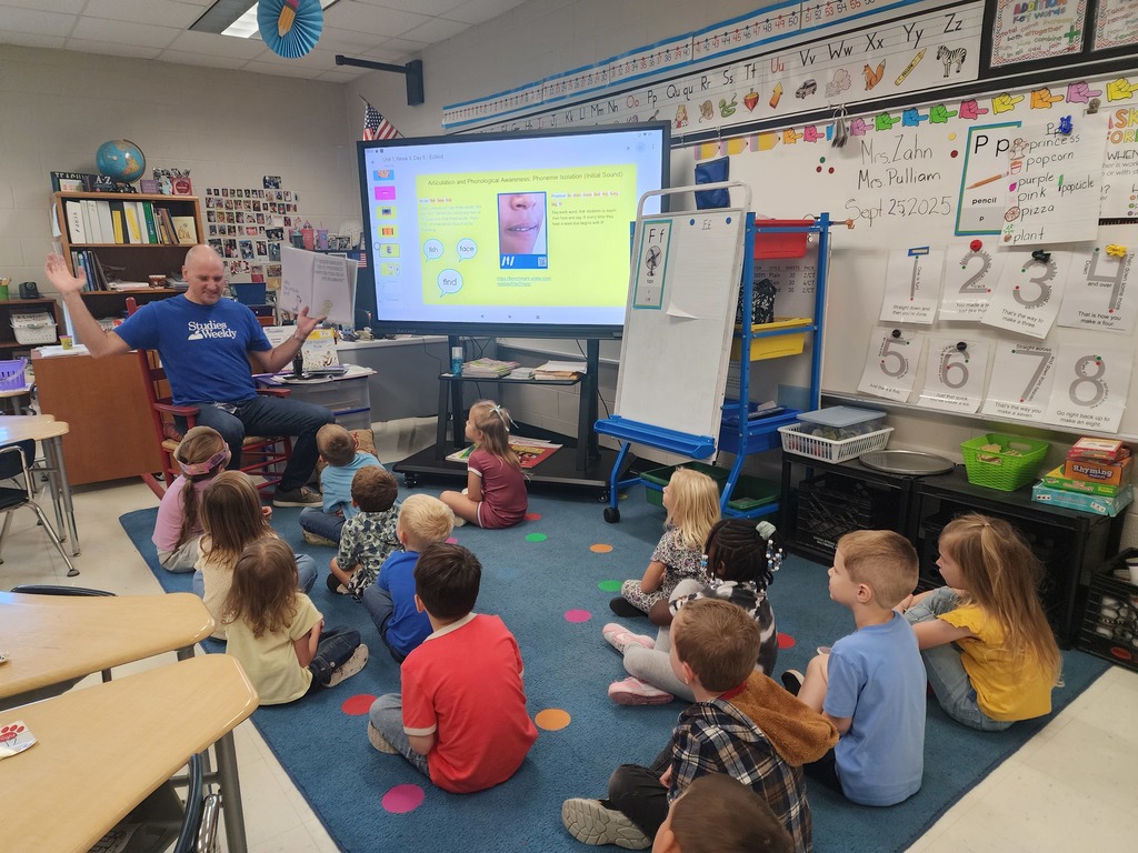 Mr. Horne reading a book to a class.