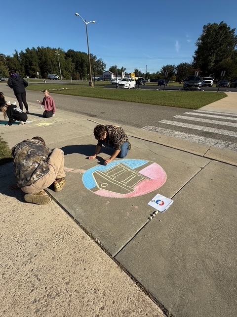 Students drawing Constitution chalk drawings at the front of the school