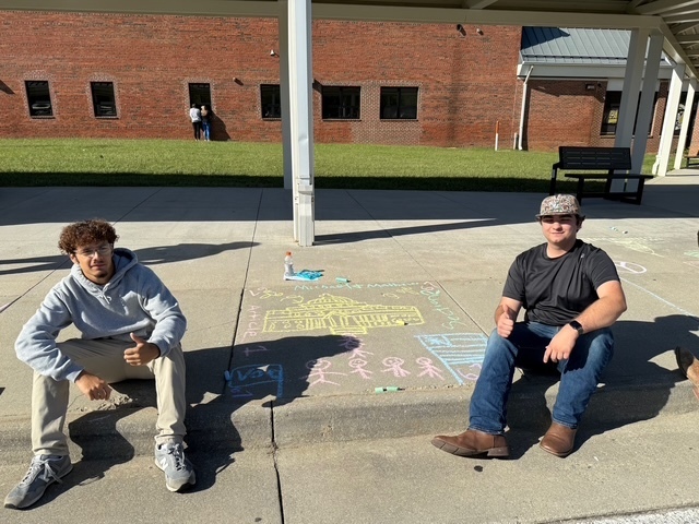 Students drawing Constitution chalk drawings at the front of the school
