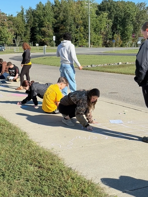 Students drawing Constitution chalk drawings at the front of the school