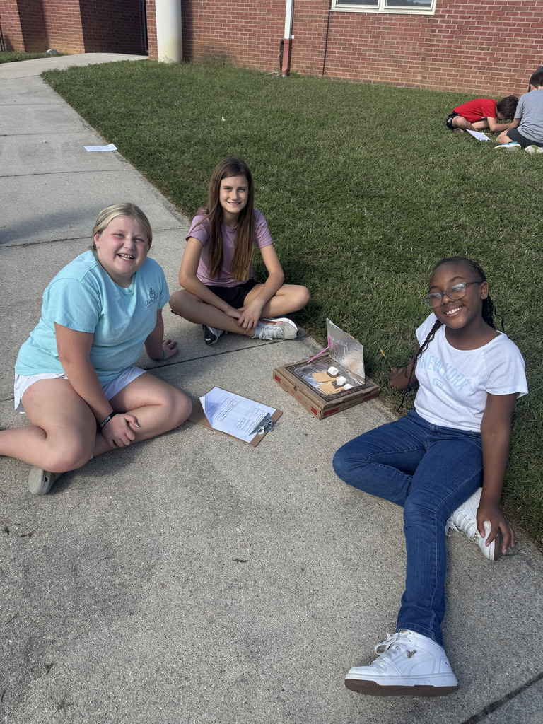 Students in grass with their solar ovens