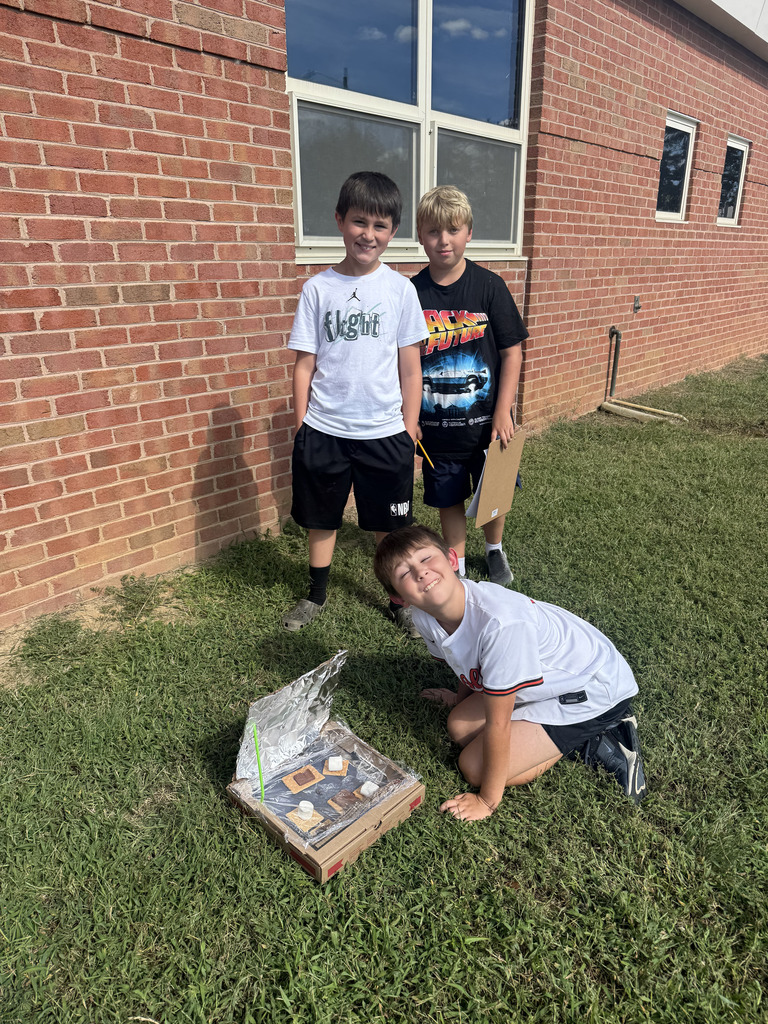 Students in grass with their solar ovens