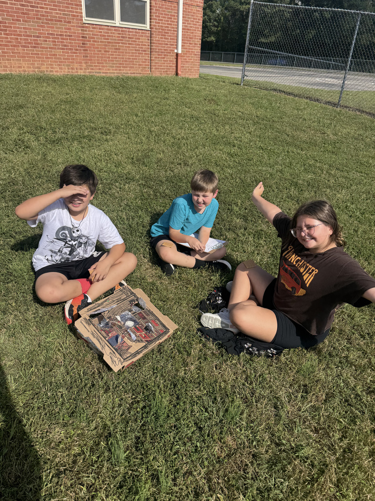 Students in grass with their solar ovens