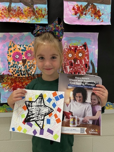 A student holding art work