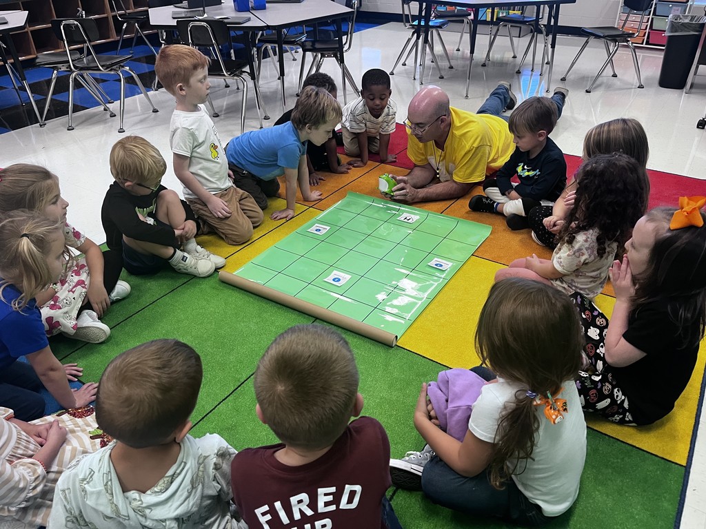 Mr. E showing a PreK class how to program a robot frog