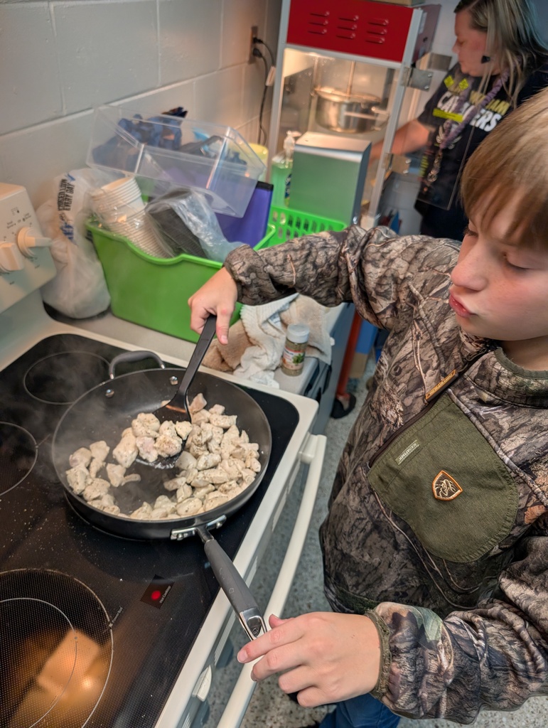 Student cooking chicken on the stove