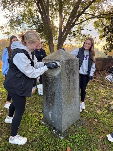 NHS students cleaning the headstones.