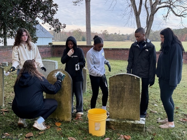NHS students cleaning the headstones.