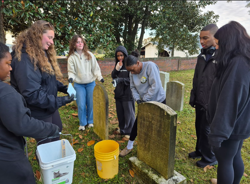 NHS students cleaning the headstones.