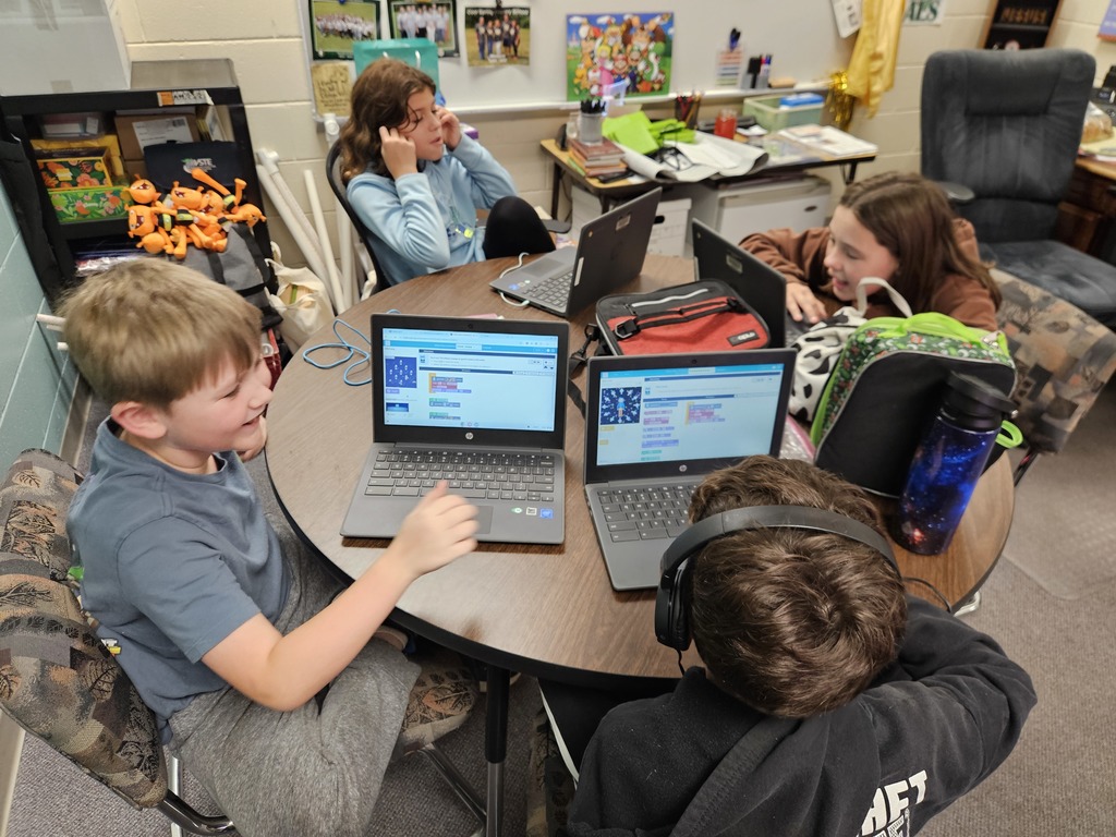 4 students working on a chromebook.