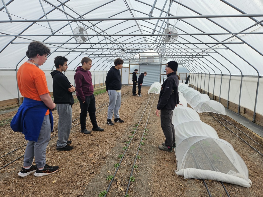 KWHS horticulture students tour a large hoop house greenhouse and observe crop production methods with a tribal guide.