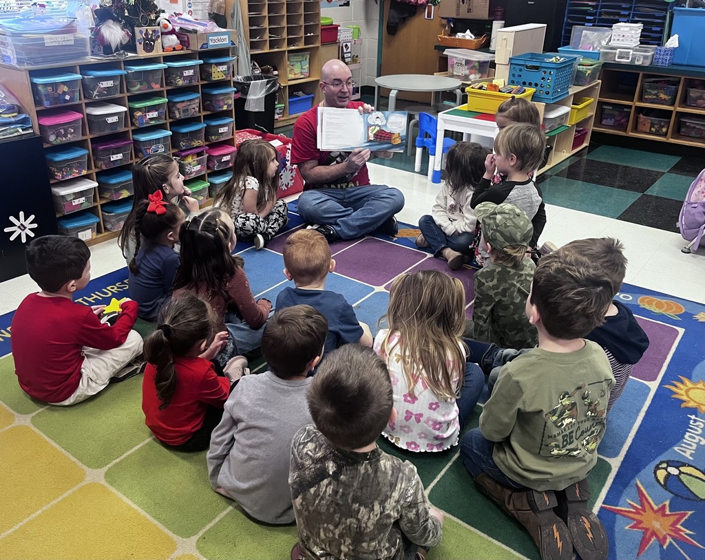 Teacher reads a book to the class.
