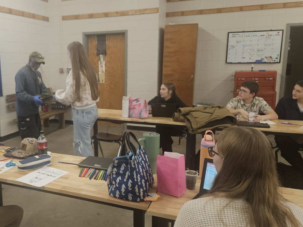 Student giving one of the custodians a wreath they made
