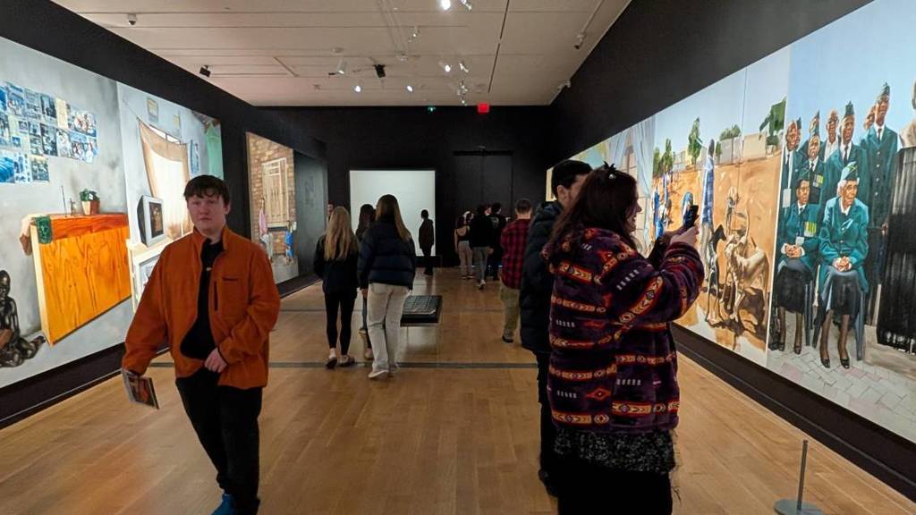 Students in front of art work at the Giants exhibit
