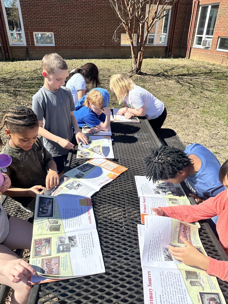 Students reading outside on a beautiful sunny day.