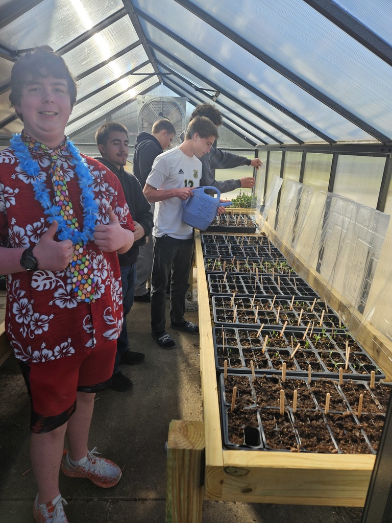 KWHS students in our greenhouse watering seeds