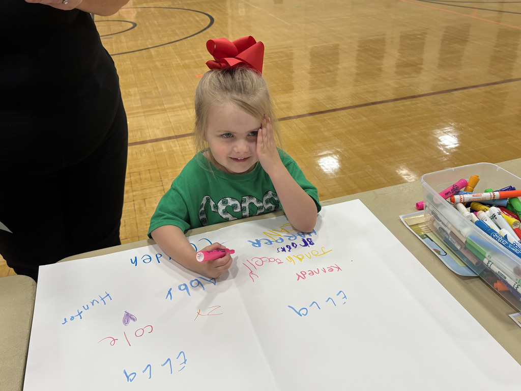 A girl signs her name to the paper