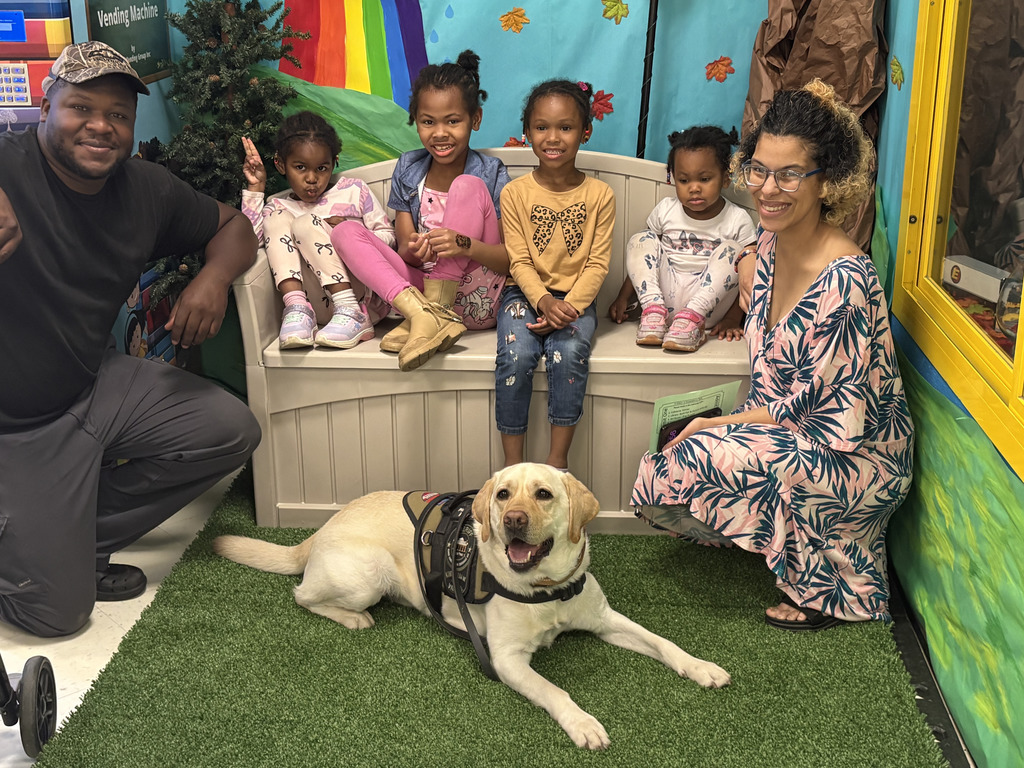 A family poses for a picture in the "garden" with Kip.