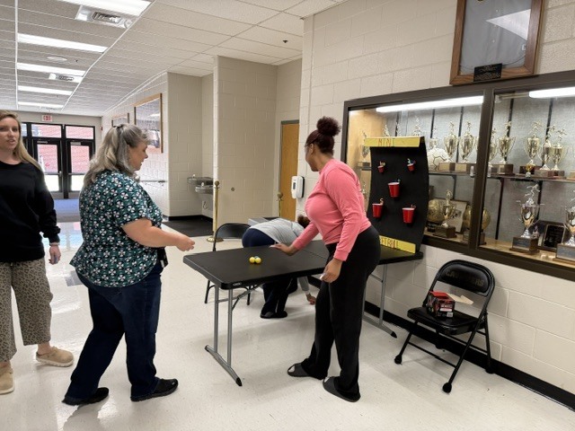 Assistant Principal Nester playing ball toss carnival game